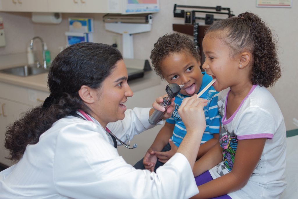 Photo of resident physician examining pediatric patients